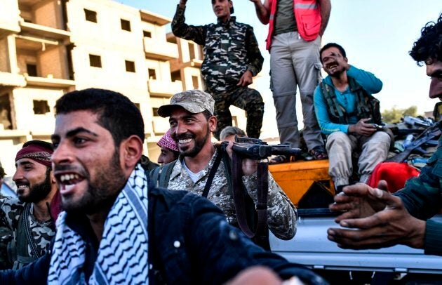 Members of the Syrian Democratic Forces (SDF) celebrate at the frontline in the Islamic State (IS) group jihadists crumbling stronghold of Raqa.