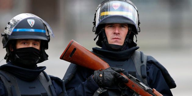 An Armed French policeman (L) and a CRS riot policeman secure the scene at the raid zone in Saint-Denis, near Paris, France, November 18, 2015 to catch fugitives from Friday night's deadly attacks in the French capital. REUTERS/Benoit Tessier