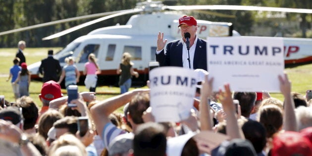 U.S. Republican presidential candidate Donald Trump speaks after arriving in his helicopter as a group of children race towards it for ride during a rally in Sarasota, Florida November 28, 2015. REUTERS/Scott Audette