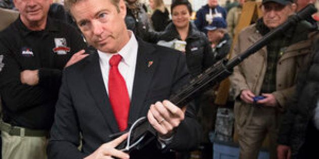 Republican presidential candidate, Sen. Rand Paul, R-Ky. handles a AR-15 style rifle as he meets with customers during a campaign stop at a gun show at Bektash Shrine Center, Saturday, Jan. 23, 2016, in Concord. (AP Photo/John Minchillo)