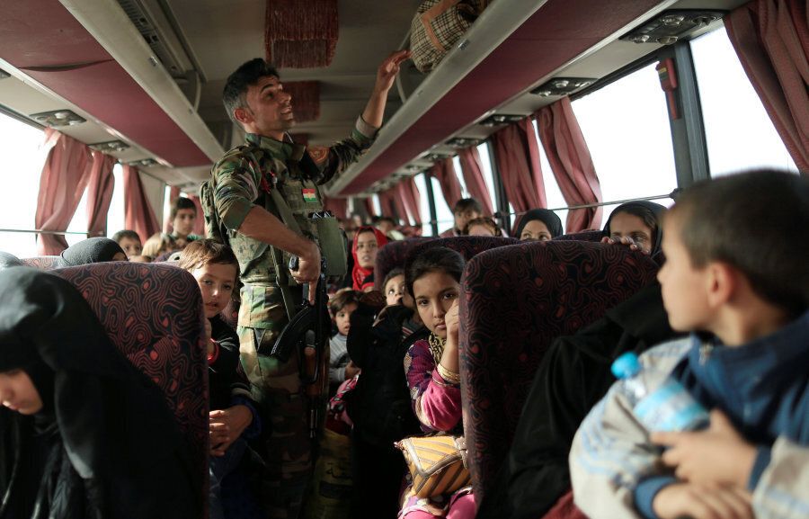 A Peshmerga soldier checks the bag compartment of people who are fleeing the fighting between Islamic State and the Iraqi army in Mosul, inside a bus at their checkpoint in Iraq November 14, 2016