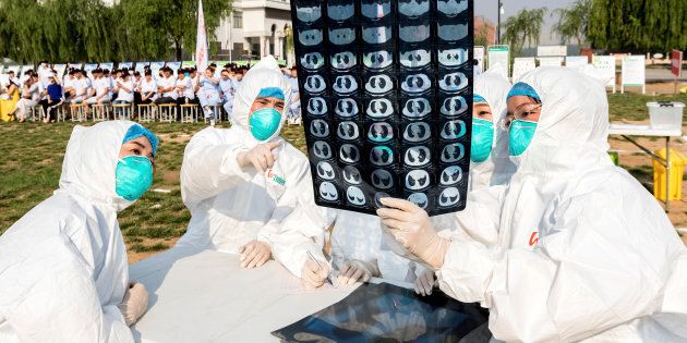People participate in an emergency exercise on prevention and control of H7N9 bird flu virus organised by the Health and Family Planning Commission of the local government in Hebi, Henan province, China.