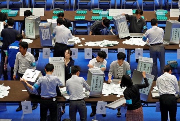 Election officials open ballot boxes to count votes after Japan's lower house election.