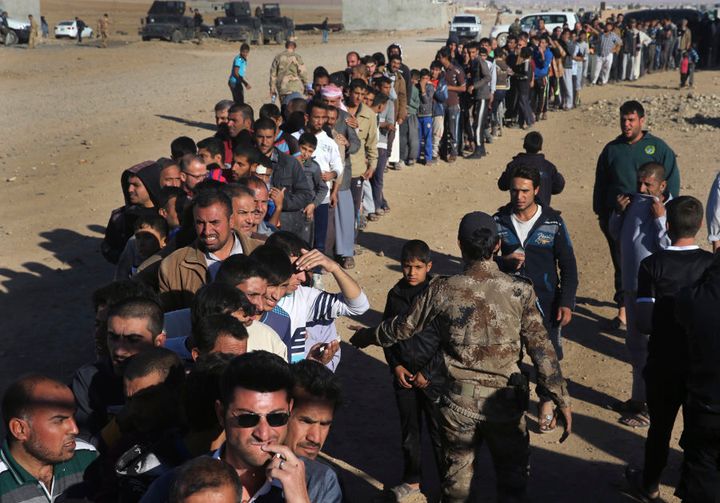 Mosul residents wait in a queue to receive food supplies, at the city's al-Samah neighbourhood on Nov. 20, 2016