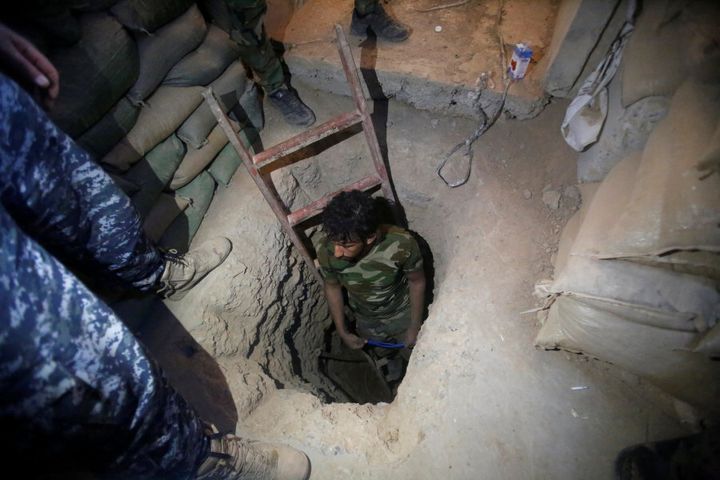 A member of the Shi'ite Badr Organisation fighter inspects a tunnel used by Islamic State militants during a battle with Islamic State at the airport of Tal Afar west of Mosul, Iraq, on November 20