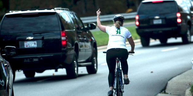 A female cyclist lets the White House know how she feels about the Trump administration as the president's motorcade passes by.