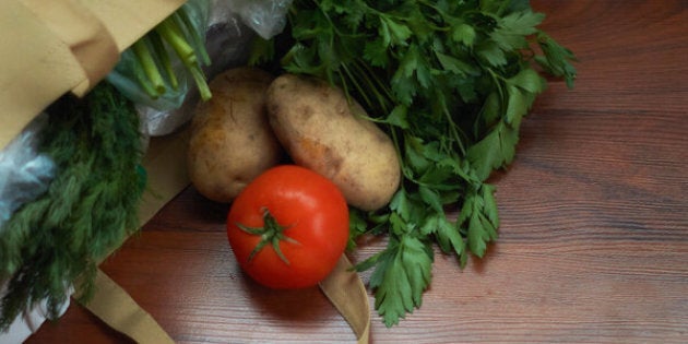 Groceries and produce in a reusable tote on wood