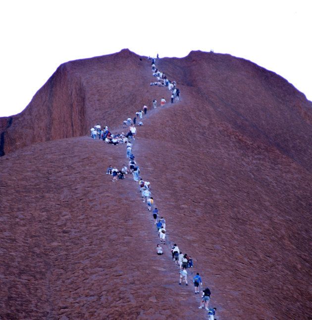 Hundreds of people continue to climb Uluru, despite signs asking people not to climb out of respect for the traditional owners of the land.