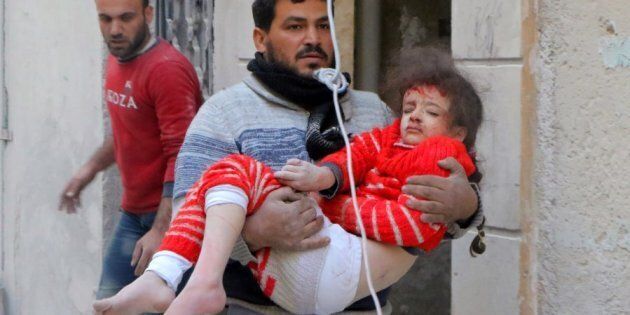 ALEPPO, SYRIA - NOVEMBER 22: A resident carries a wounded child girl pulled out of a debris after the air strikes carried out by the war crafts belonging to Assad regime forces on the opposition-controlled Al Moyaser neighbourhood of Aleppo, Syria on November 22, 2016.