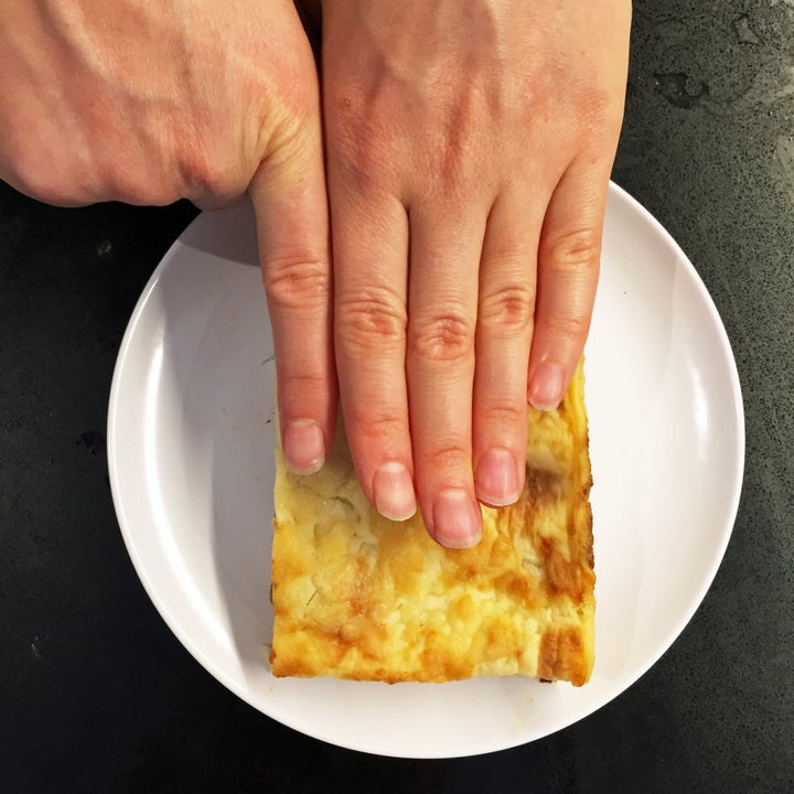 The finger width method in action to measure a slice of lasagna.