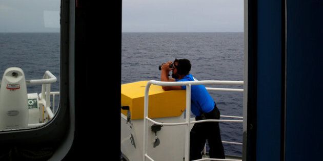 A crew member on the Migrant Offshore Aid Station (MOAS) ship Topaz Responder looks out for migrants in distress in international waters, off the coast of Libya, June 21, 2016. REUTERS/Darrin Zammit Lupi SEARCH