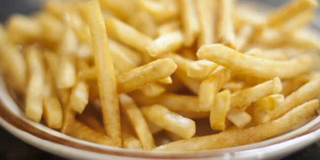 Plates of french fries in diner setting.