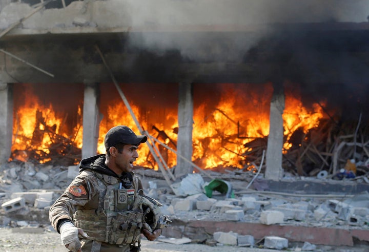 An Iraqi special forces soldier shouts in front of a burning house after an Islamic State suicide car bomb attack against Iraqi special forces during clashes in Mosul, Iraq, November 19, 2016