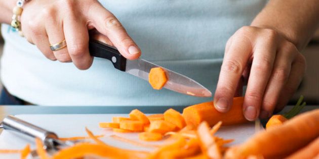 Woman cutting a carrot into slices