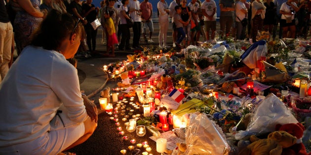 A man reacts near the scene where a truck ran into a crowd at high speed killing scores and injuring more who were celebrating the Bastille Day national holiday, in Nice, France on Thursday.