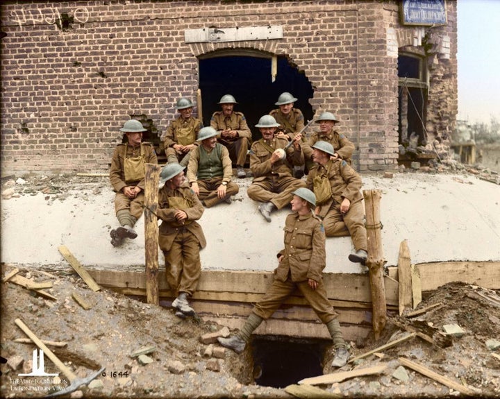 A Canadian giving his comrades some music on his instrument which he has just made. July 1917.