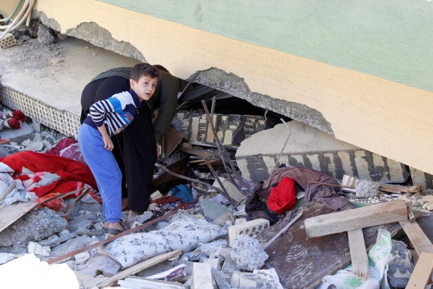 A child looks at a damaged building in the town of Darbandikhan, near the city of Sulaimaniyah, in the semi-autonomous Kurdistan region, Iraq.