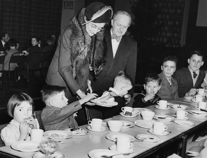 Noel W Lamidey with Lady Harrison, and migrant children at Australian House, 1950.