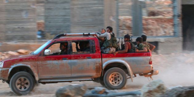 Fighters of the Syrian Islamist rebel group Jabhat Fateh al-Sham, the former al Qaeda-affiliated Nusra Front, ride on a pick-up truck in the 1070 Apartment Project area in southwestern Aleppo, Syria August 5, 2016. REUTERS/Ammar Abdullah