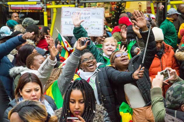 Exiled Zimbabweans of all races gather outside the Zimbabwe Embassy in London to celebrate the military intervention in Zimbabwe.