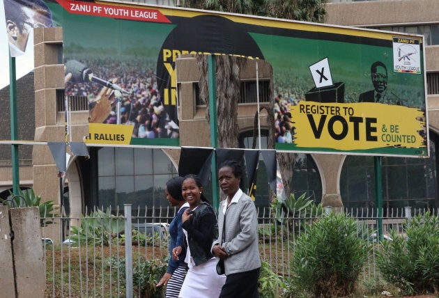 People walk past torn billboards of Zimbabwean President Robert Mugabe's Zimbabwe African National Union - Patriotic Front (ZANU-PF) in Harare.