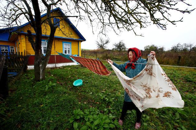 Valentina Zhih, 77, hangs linen on the washing line at her house in the village of Danilovichi, Belarus.