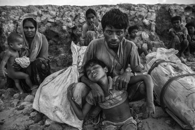 A Rohingya Muslim refugee boy is held by his father after arriving by boat to Shah Porir Dwip on October 30, 2017 near Cox's Bazar.