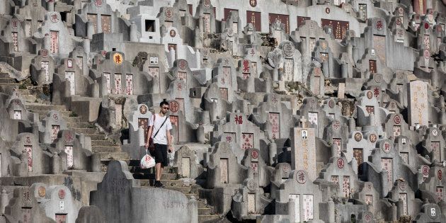 A man walks past tombstones at a cemetery ahead of the Ching Ming Festival, or grave-sweeping day, in Hong Kong.
