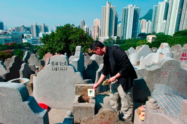 A man burns paper offerings at the grave of a relative during the Chung Yeung grave sweeping festival at a cemetery in Hong Kong.