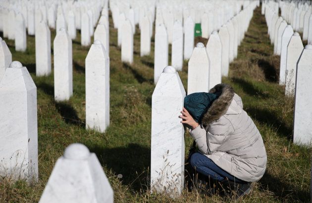 A woman sits by the grave of a family member near Srebrenica, Bosnia and Herzegovina, after the court ruling was handed down.