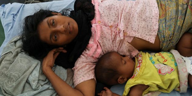 Rohingya refugee Ufaira Begom, 25, who suffers from vomits and dehydration, lies on a hospital bed with her 6-month-old baby Shehena at the Norwegian-Finnish Red Cross field hospital at Kutupalong refugee camp near Cox's Bazar, Bangladesh.