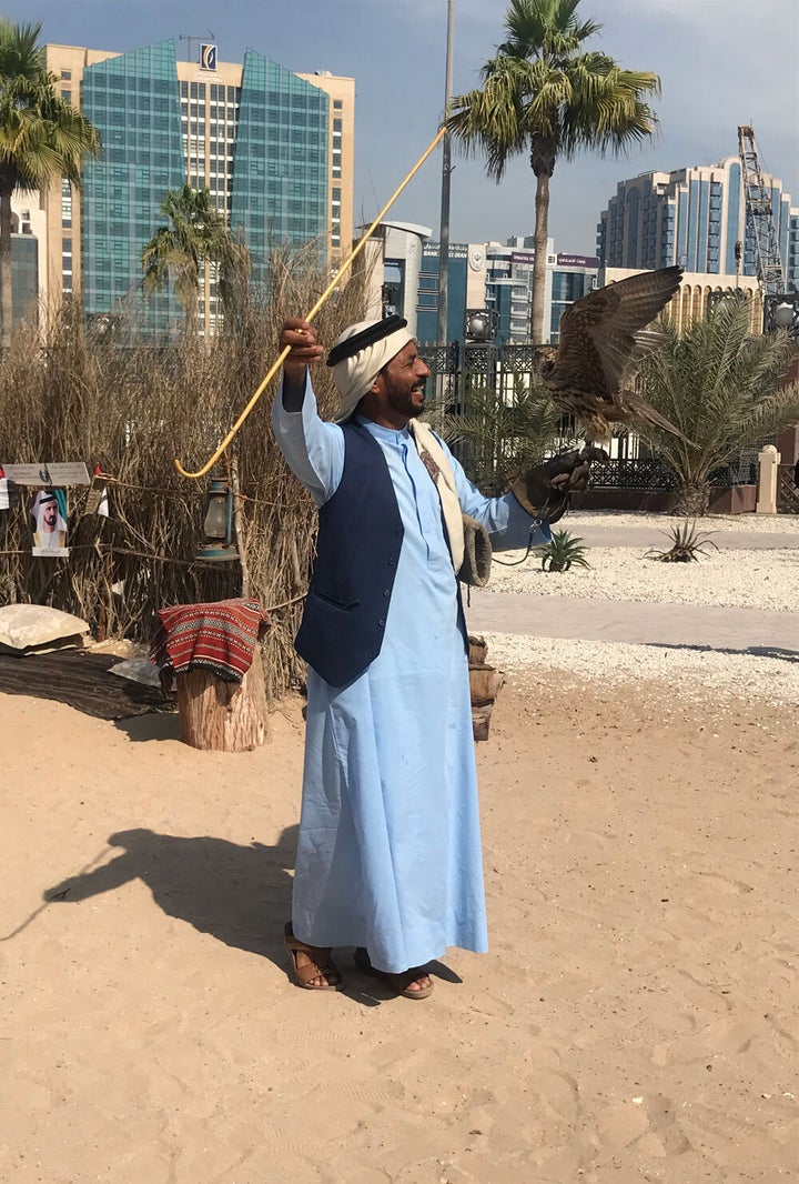 A man poses with his falcon in the historical Al Fahidi District.