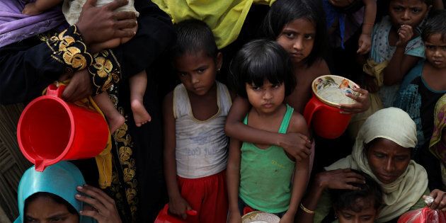 Rohingya women and children wait to get distributed meals at Moynarghona refugee settlement near Cox's Bazar, Bangladesh.