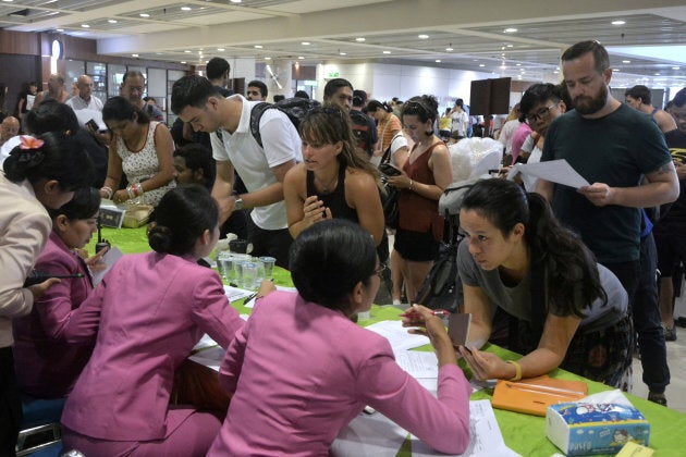 Passengers ask staff about their flights after Ngurah Rai airport closed their operation due to eruption of Mount Agung.