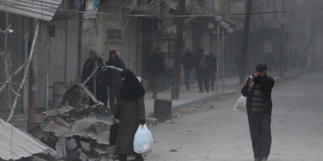 People carry their belongings as they flee deeper into the remaining rebel-held areas of Aleppo