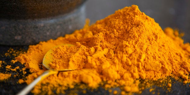 A pile of ground tumeric on a granite surface