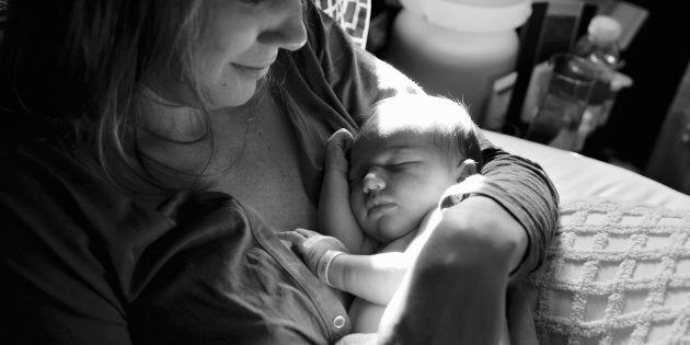 Baby girl (0-3 months) sleeping in mother's arm, close-up