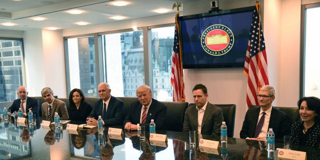 (L-R) Amazon's chief Jeff Bezos, Larry Page of Alphabet, Facebook COO Sheryl Sandberg, Vice President elect Mike Pence, President-elect Donald Trump, Peter Thiel, co-founder and former CEO of PayPal, Tim Cook of Apple and Safra Catz of Oracle attend a meeting at Trump Tower December 14, 2016 in New York. (TIMOTHY A. CLARY/AFP/Getty Images)