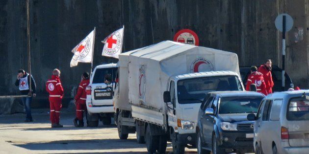 Staff from the International Red Cross and from the Syrian Red Crescent are seen in embattled city of Aleppo as efforts were underway to evacuate rebel fighters and their families from rebel-held areas on December 15, 2016.Russia, Syrian military sources and rebel officials confirmed that a new agreement had been reached after a first evacuation plan collapsed the day before amid fresh fighting. Syrian state television reported that some 4,000 rebels and their families were to be evacuated. / AFP / STRINGER (Photo credit should read STRINGER/AFP/Getty Images)