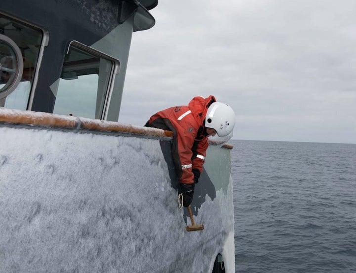 Elissa Sursara removing ice from the bridge wing of the MV Sam Simon.