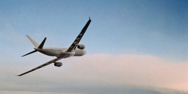 Jet airplane flying above clouds, low angle view