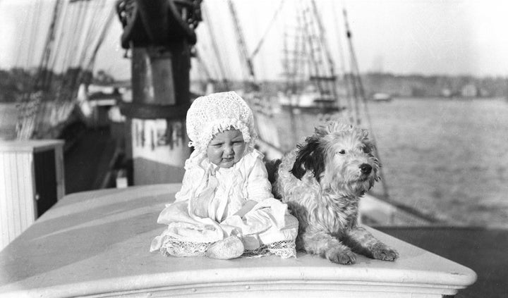 Check out the 1900s baby fashion. As for the dog, his coat doesn't date.