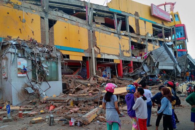 Residents stand in front of a damaged shopping mall after an earthquake hit Palu, Sulawesi Island, Indonesia September 29, 2018. Antara Foto/Rolex Malaha via REUTERS