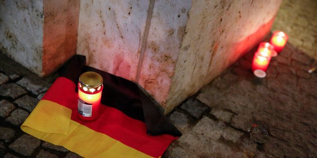 A candle is burning on a German national flag near the site where a truck ploughed through a crowd at a Berlin Christmas market on Breitscheidplatz square near the fashionable Kurfuerstendamm avenue in the west of Berlin, Germany, December 20, 2016 REUTERS/Fabrizio Bensch TPX IMAGES OF THE DAY