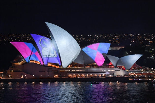 Protestors use torches and other lights to shine onto the sails of the Opera House during a promotional light show.