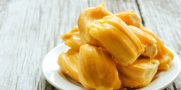 Ripe Jackfruit slices on wooden background, selective focus