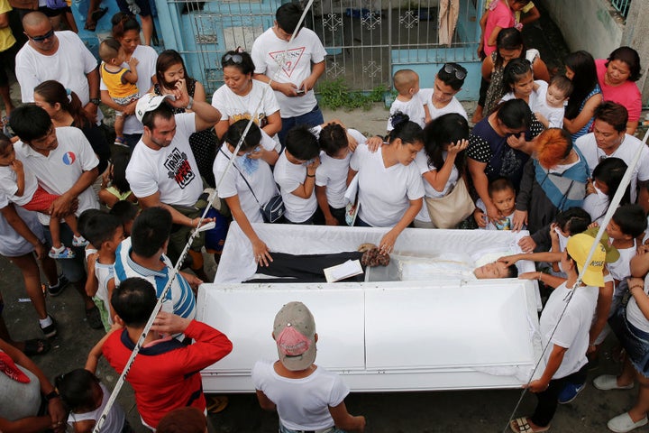 Relatives and friends gather around the coffin of Benjamin C. Visda Jr, who was killed during a police drugs bust in November.