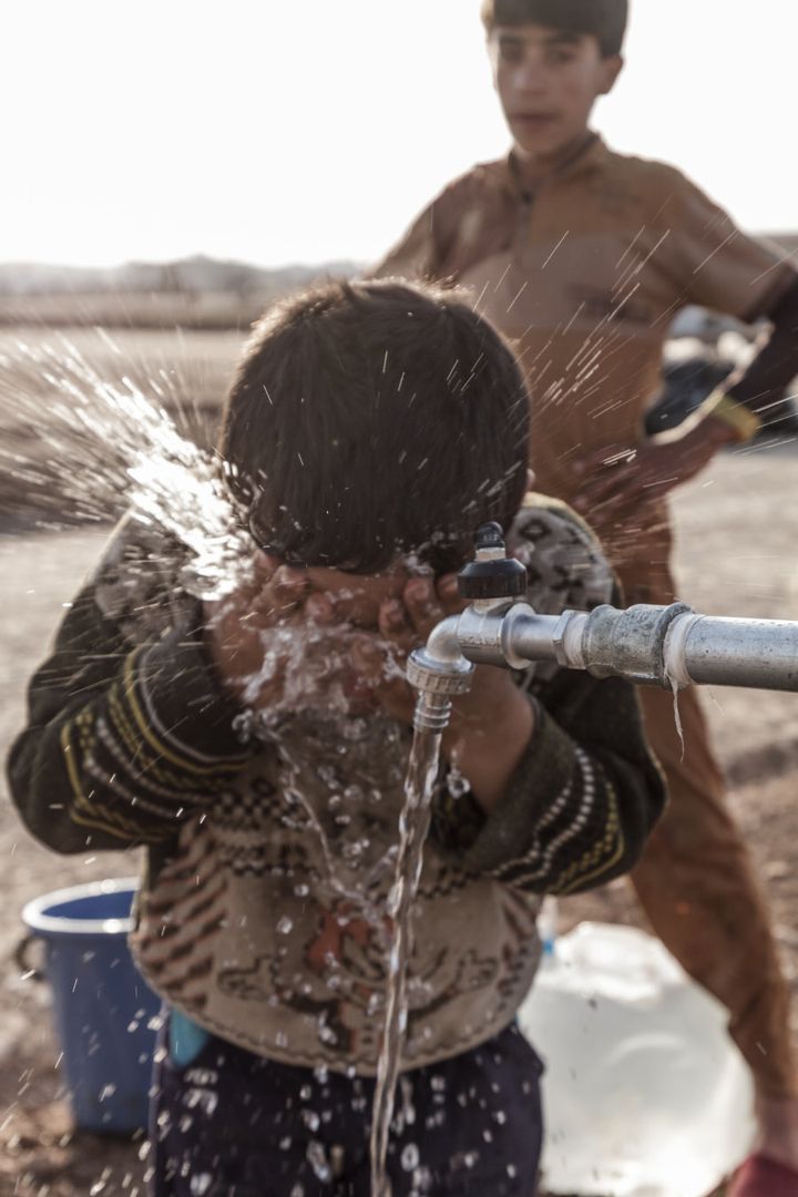 Children wash their faces in Hassansham camp around 50km east of Mosul. Hundreds of families have been arriving every day after fleeing the fighting in Mosul and surrounding areas. Oxfam has installed tanks for clean water in the camp and is maintaining toilets.