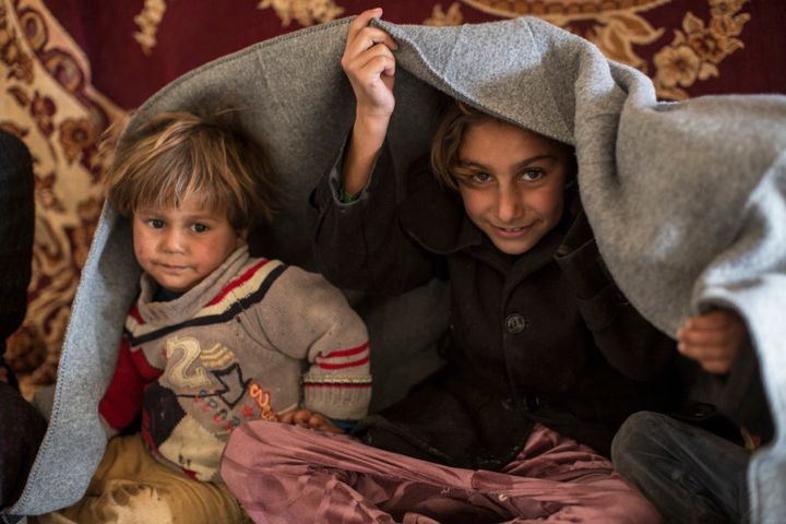 *Mariam, 8, and her brother *Mahmoud, 2 keep warm thanks to a blanket provided by Oxfam, at a camp for people who've fled their homes because of fighting against Islamic State in northern Iraq, near the town of Hassan Sham, Kurdistan, Iraq, on December 1, 2016. Her family's town was captured by Islamic State in 2014, who then forced them to live in Mosul, where Mariam's grandmother said she'd seen IS stoning women in public executions. The family had been visiting relatives when the neighbourhood they were in was taken by Iraqi Security Forces. Now the five of them share a tent in this camp.