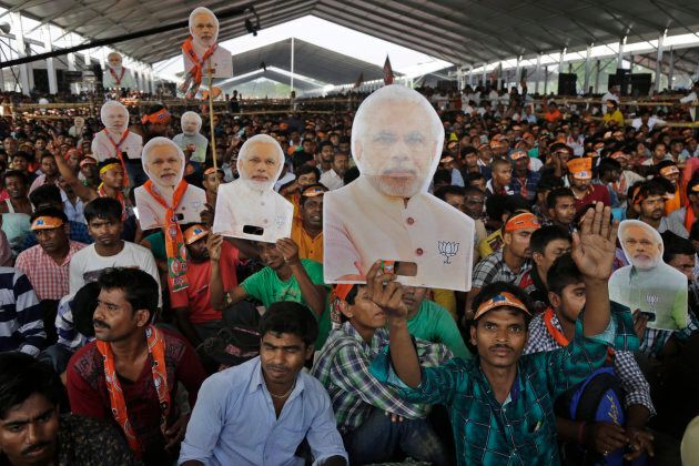 Supporters of India's ruling party Bharatiya Janata Party (BJP) hold cut out busts of Indian Prime Minister Narendra Modi as they attend an election rally in Kolkata, India, Wednesday, April 3, 2019. India's general elections will be held in seven phases from April 11 to May 19. (AP Photo/Bikas Das)